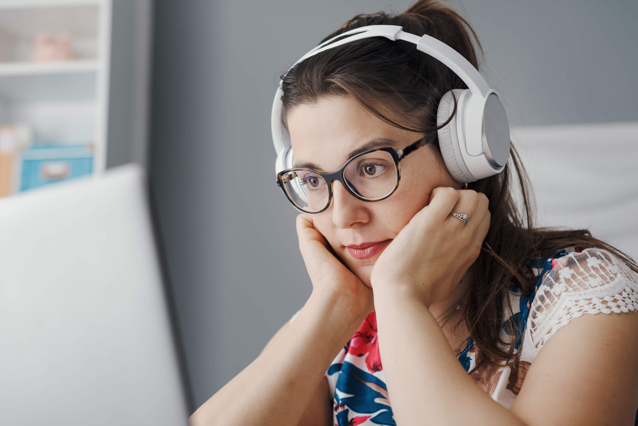 Woman looking at laptop with headphones, CBT, Self paced, learning